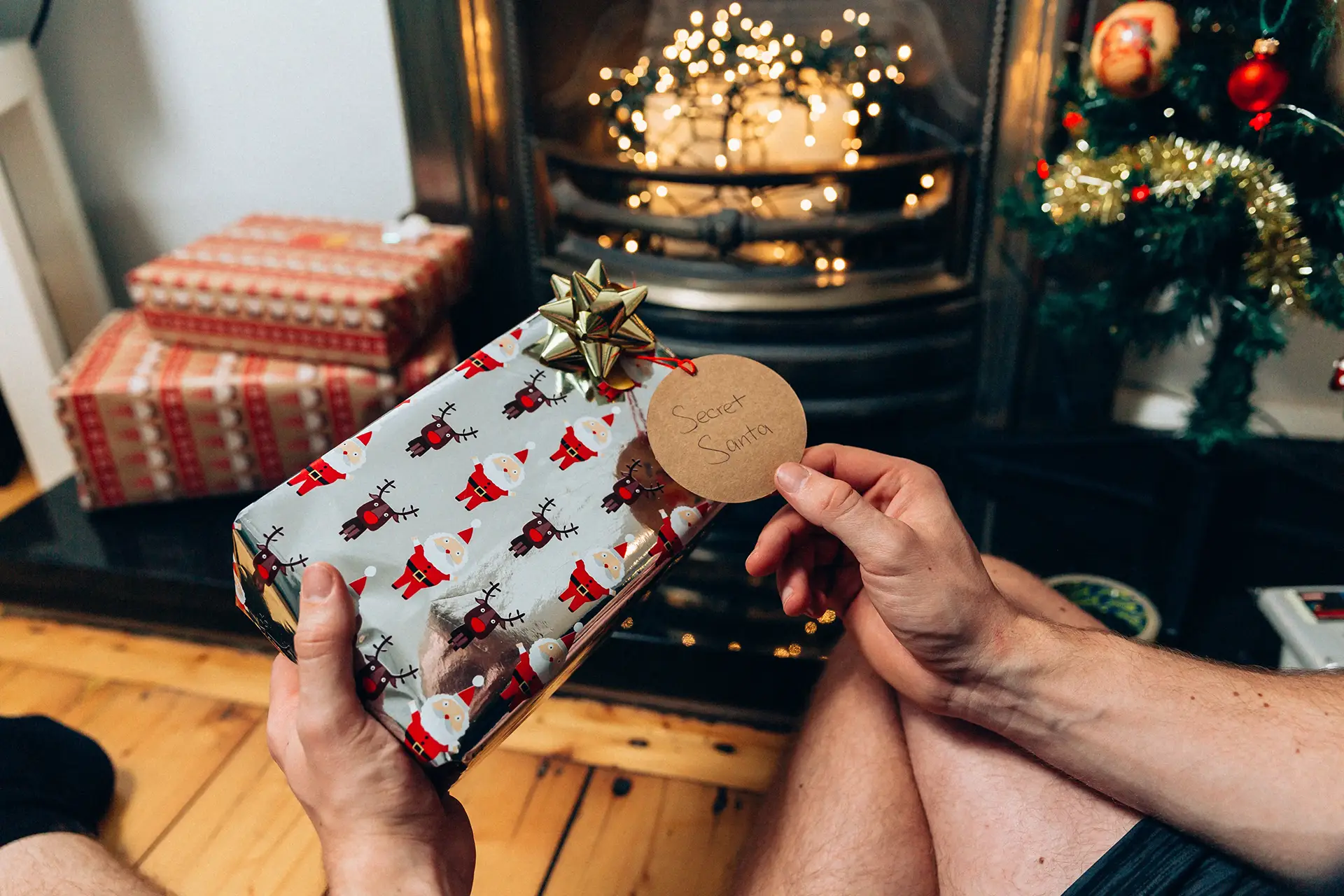 Person holding Christmas present infront of fire