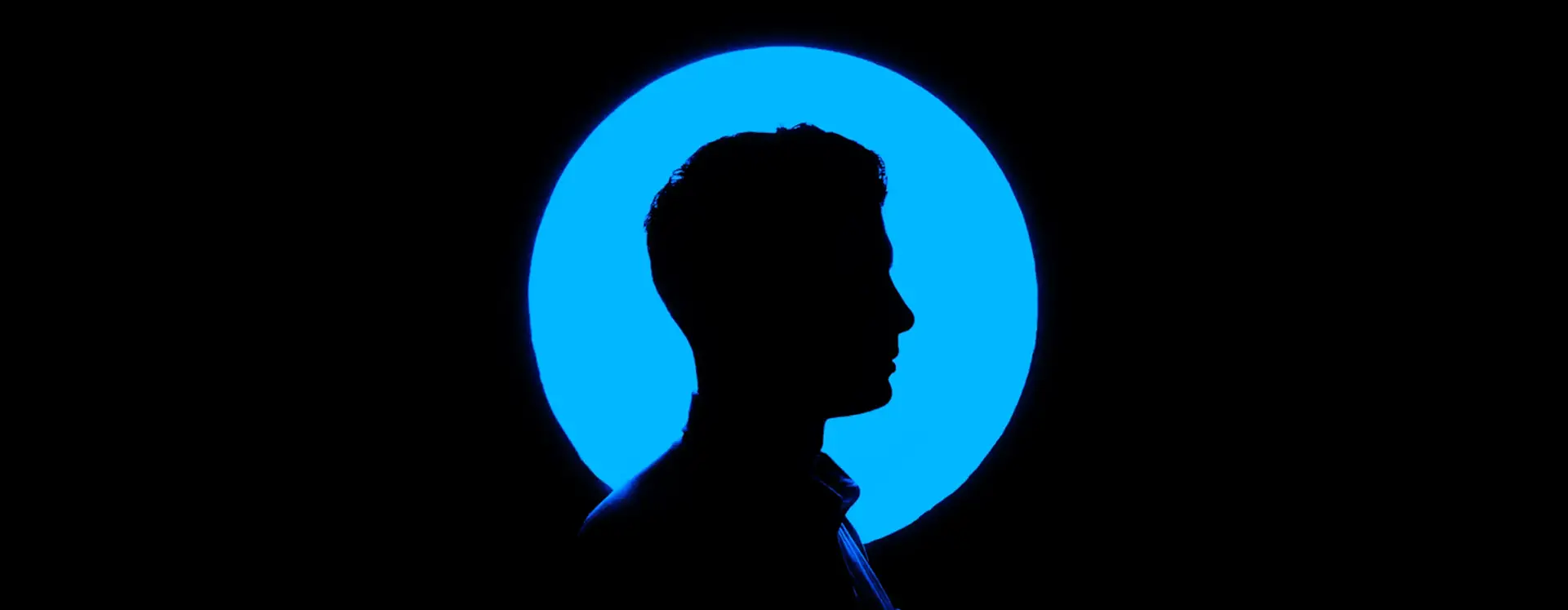 Silhouette of a person's profile against a circular blue backlight