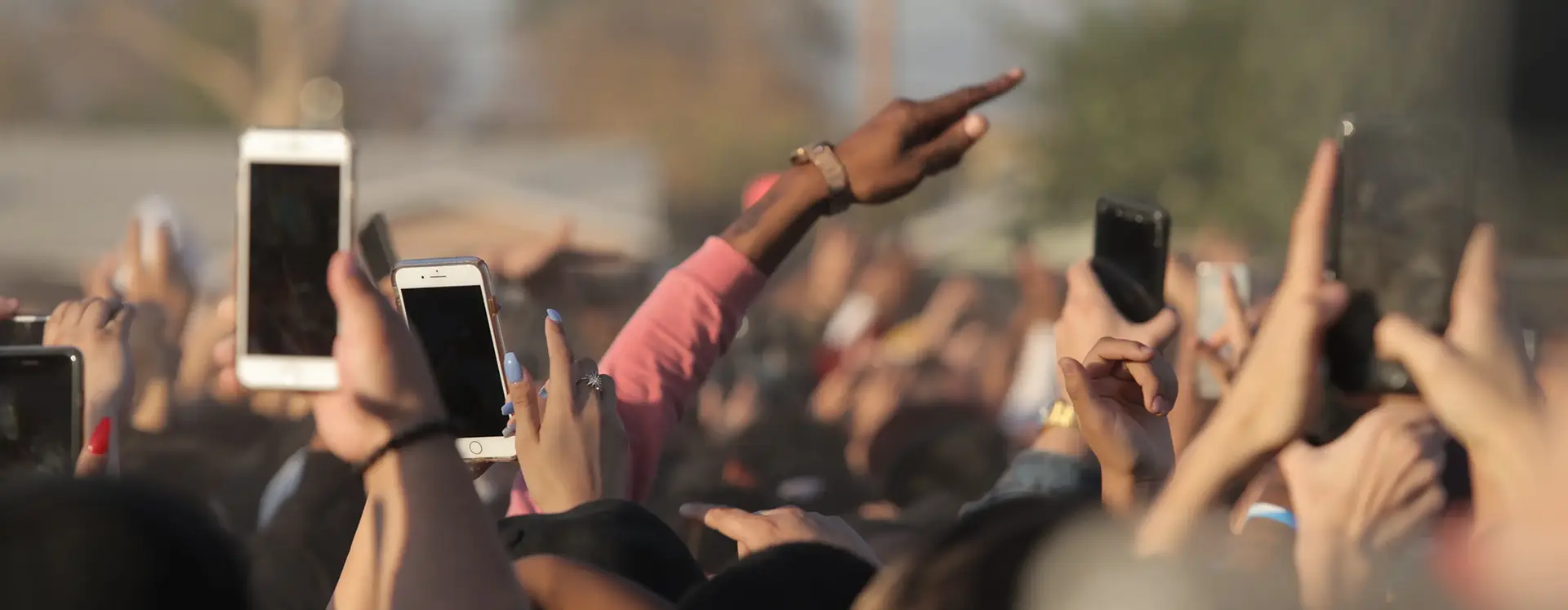 Crowd of people recording with their smartphones at an outdoor event